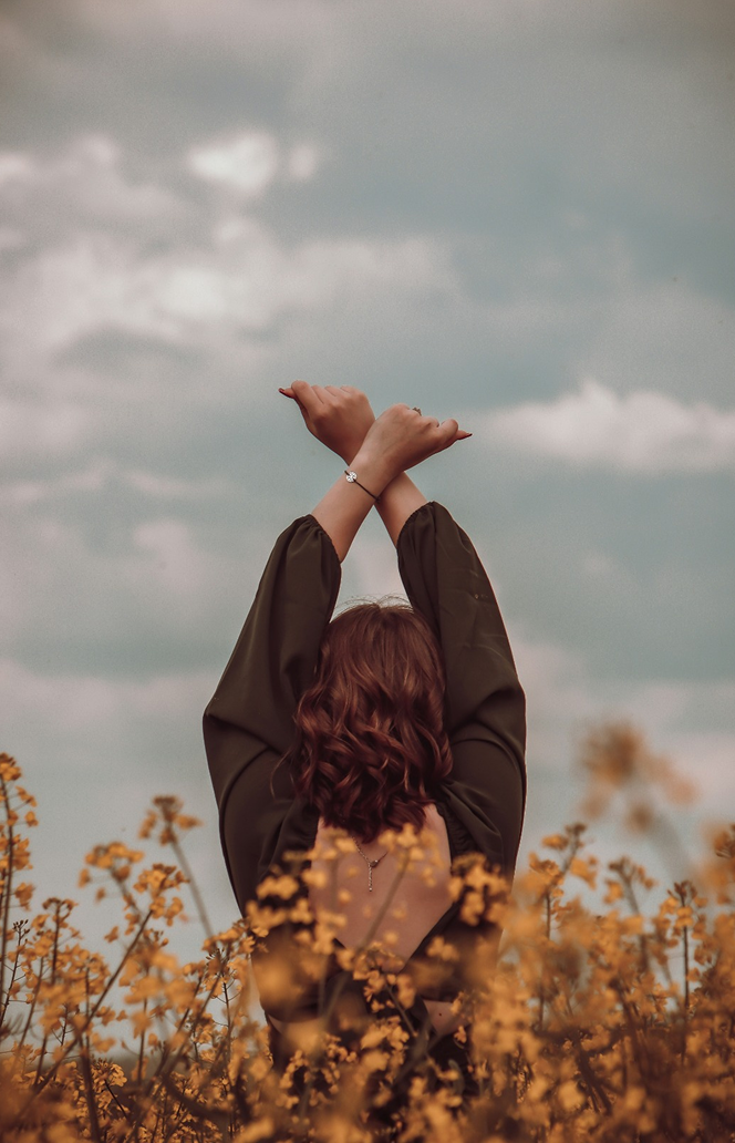 Pessoa ao ar livre com os braços erguidos, simbolizando leveza e recomeço.