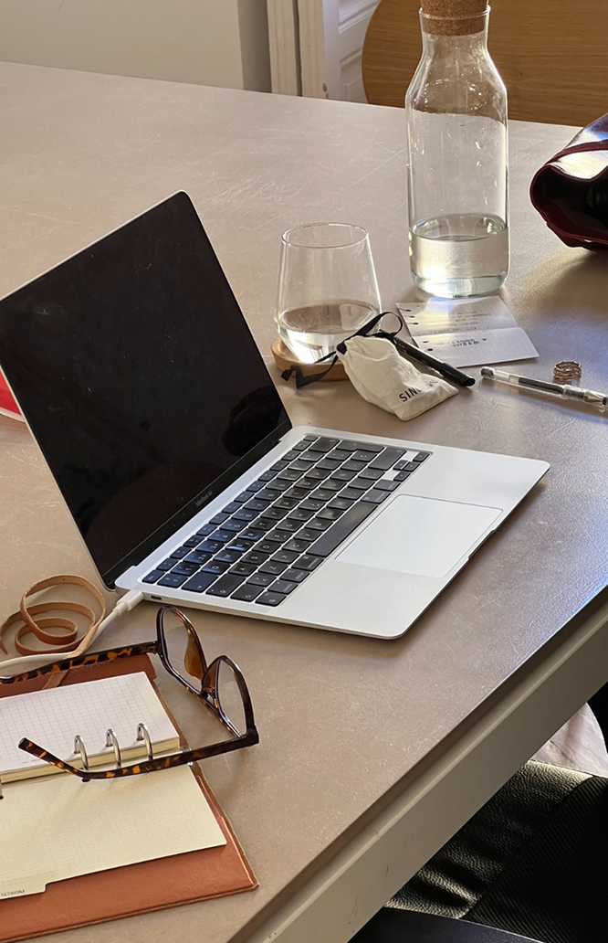 Mesa de trabalho com notebook e materiais, representando rotina e estrutura.